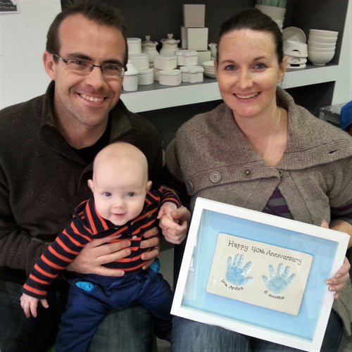 Proud parents receiving the clay imprint of their babies hand prints.