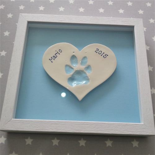 Small heart Clay Imprint with dog paw print in pastel blue with pastel blue backboard and white frame.