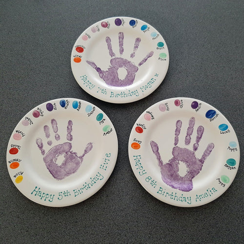 Three keepsake plates from parties held at Create It, each with fingerprints of the guests and a hand print of the birthday child.