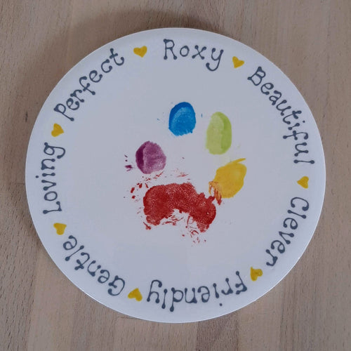 Small round tile with rainbow paw print and personalisation around the outside edge.