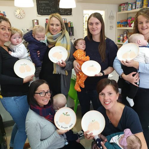 A party of new mums, displaying their baby's bumkin plates, where the babies bottoms were printed onto plates and turned into a pumpkin.