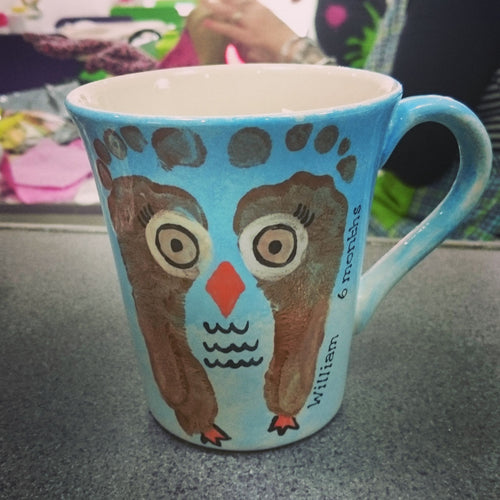 Cone Flare Mug with two brown footprints and additional detail added to make the prints into an owl. 
