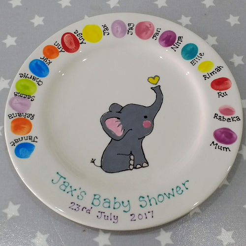 A keepsake plate from a baby shower with the fingerprints of all the guests and painted baby elephant in centre.