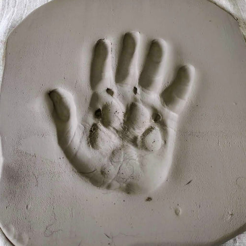Clay Imprint before firing with hand print and paw print inside.