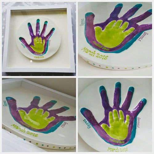 Family Clay Imprint. Green hand inside purple hand inside teal hand with off white backboard and white frame.