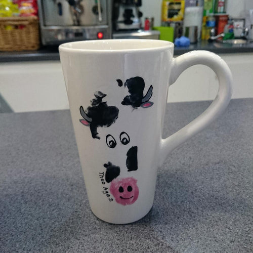 Black and white footprint on a Tall Latte Mug turned into a cow's head with added cute eye detail.