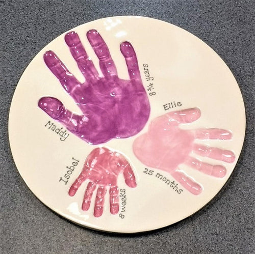 Round Clay Imprint with three sibling hand prints in purple, dark pink and pastel pink.  Unframed. 