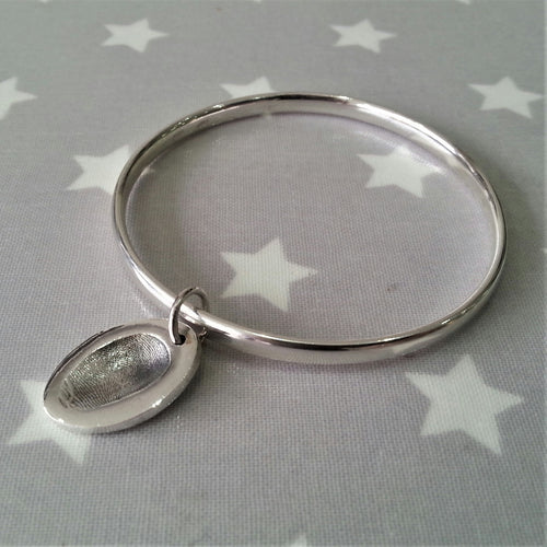 Love Prints medium oval charm with fingerprint on a sterling silver bangle.
