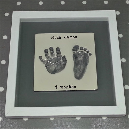 Square Clay Imprint with hand and footprint in grey with grey back board and white frame.