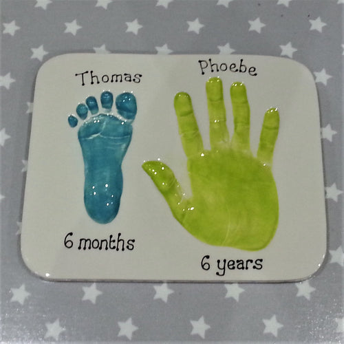Rectangle Clay Imprint with small footprint and older sibling's hand print.  Footprint in teal, hand print in lime green.  Unframed. 