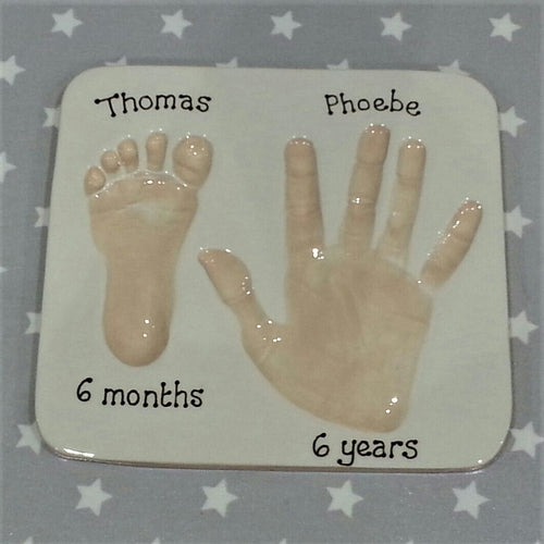 Square Clay Imprint with small footprint and older sibling's hand print.  Unframed. 