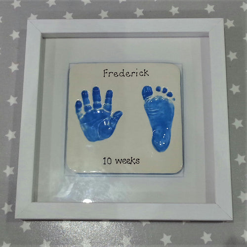 Square Clay Imprint with hand and footprint in blue with white backboard and white frame.