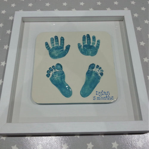Rectangle Clay Imprint with two hand prints and two footprints in teal with white backboard and white frame.