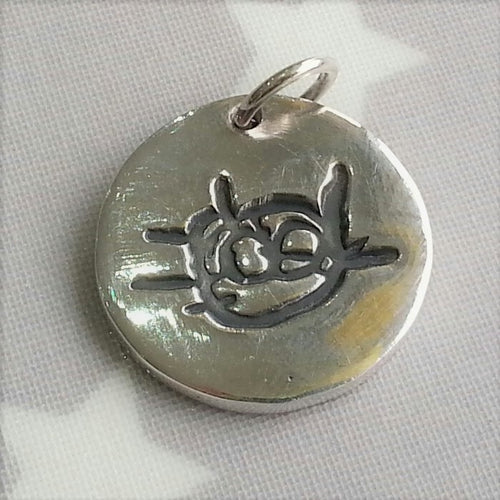 Love Prints medium circle charm with child's drawing of a cat.