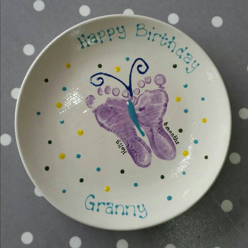 Large Coupe Plate with two purple feet turned into a butterfly and decorated with different coloured spots, as a gift for Granny.