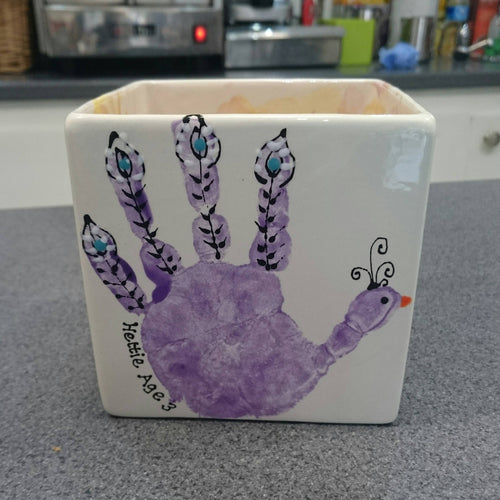 Purple hand print on square Herb Pot, turned into a peacock by adding feather detail.