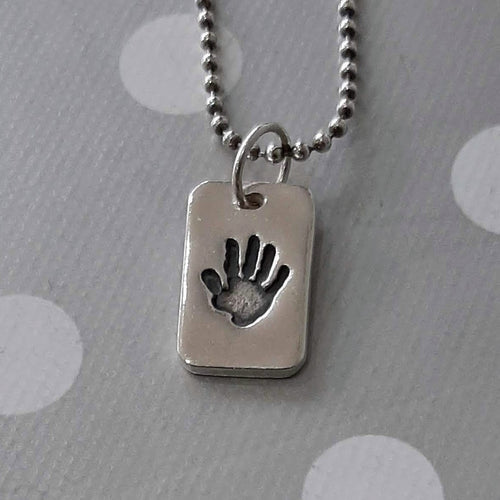 Love Prints dog tag style charm with hand print on a bead chain.