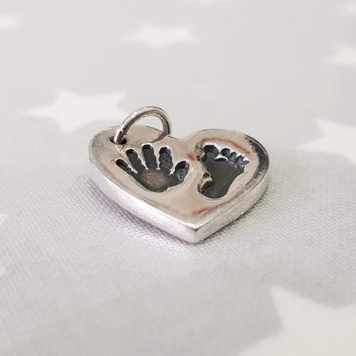 Love Prints heart charm with hand and foot print.  Side view.