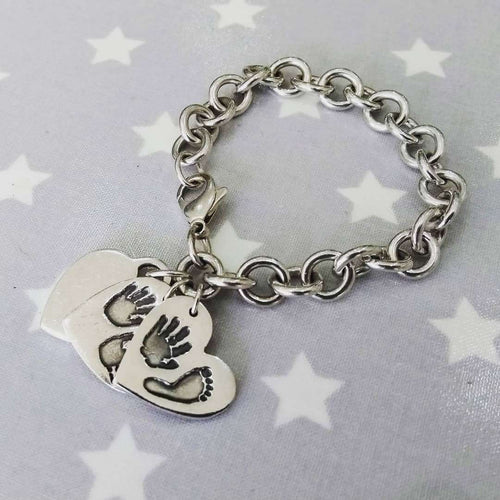 Love Prints medium heart charms with hand and foot print on sterling silver bracelet.