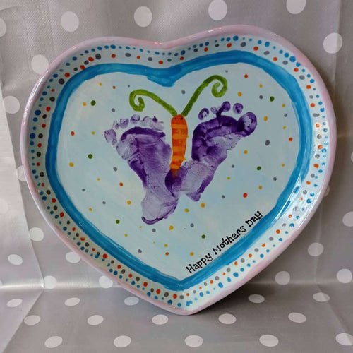Heart Plate decorated with light colours and dots with two purple footprints turned into a butterfly.