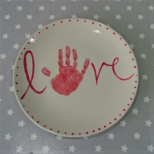 Large Coupe Plate with red hand print making the O in the word LOVE with decorative dots around the edge.