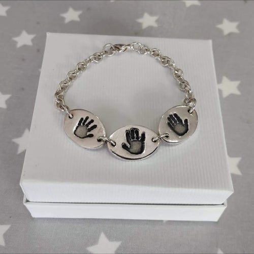 Love Prints hand print necklace. 3 medium oval charms with sterling silver bracelet connection.