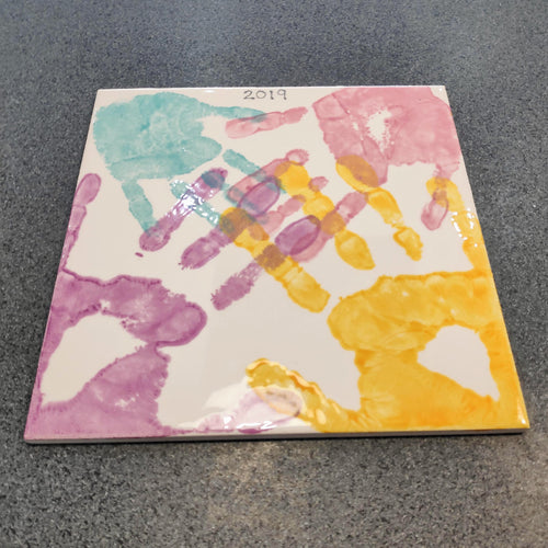 Large Square Tile with family hand prints in purple, teal, pink and yellow.